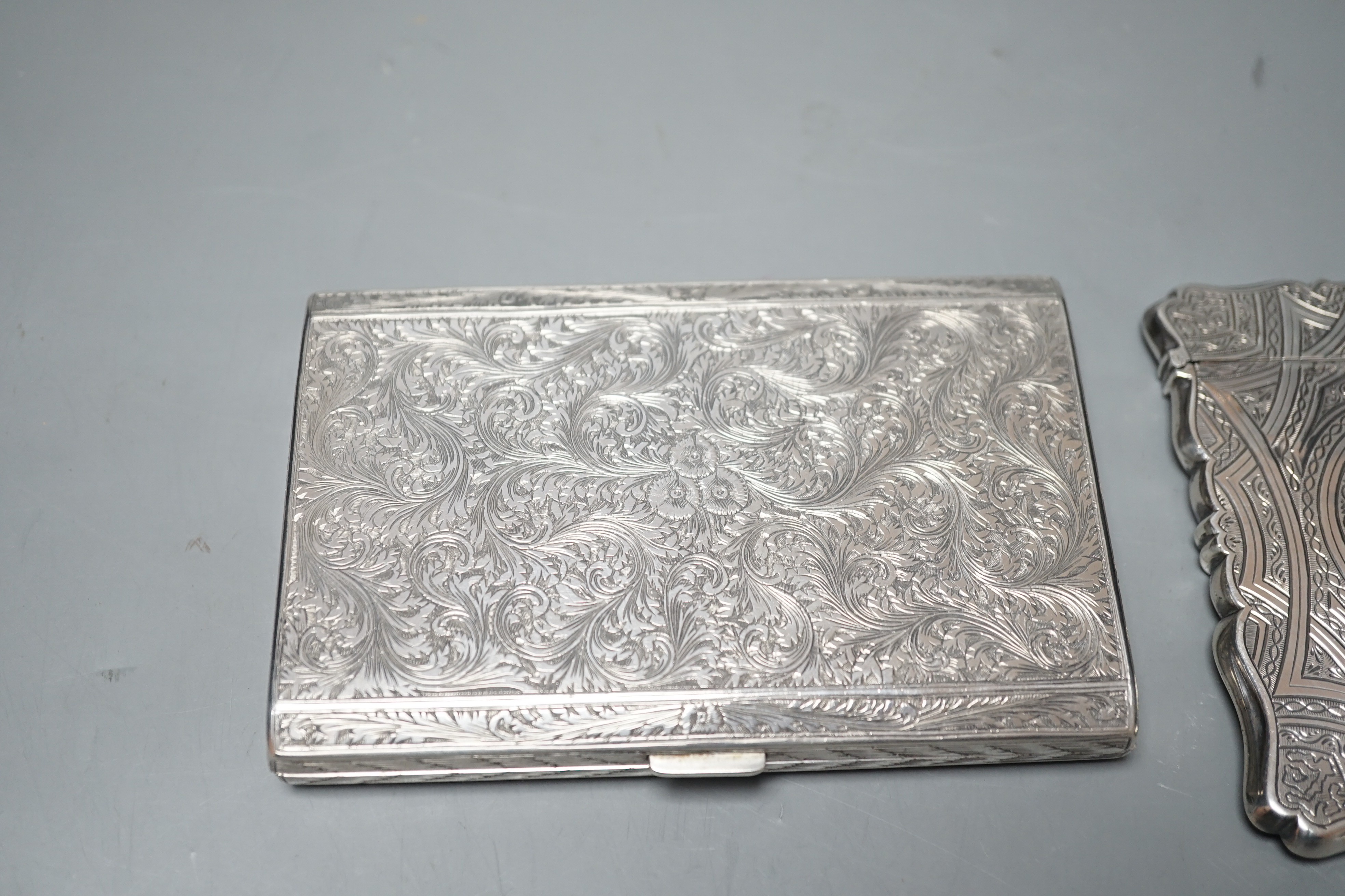 An engraved white metal card case, makers mark only AT, 97mm, together with an engraved 800 standard cigarette case, gross weight 8.9oz.